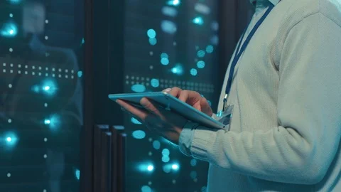 IT server specialist using digital tablet monitoring network data servers in Stock Footage 119233674