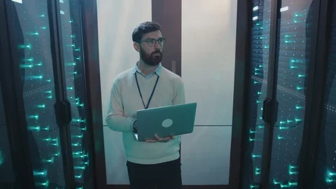 IT server specialist working on laptop inspecting network server supercomputers Stock Footage 119231663