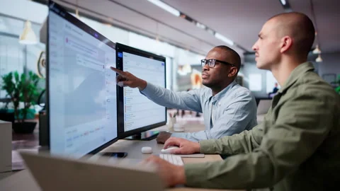 IT Service Managers Collaborating At Desk Using Software Stock Footage 335878296