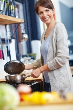 It should be ready in half an hour. an attractive woman preparing food on the Stock Photos