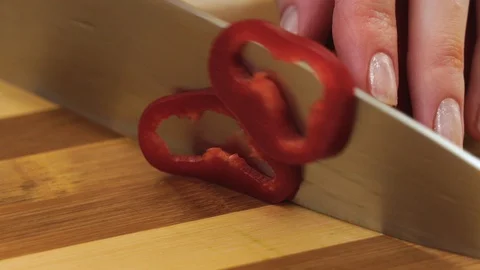 It is slicing of the long red pepper into the rings by a kitchen steel knife. Stock Footage 128329066