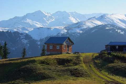 It snowed on the top of the mountain. Spring. A red house. Stock-Fotos