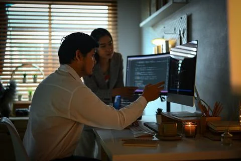 IT software developers team brainstorming and programming on desktop computer in Stock Photos