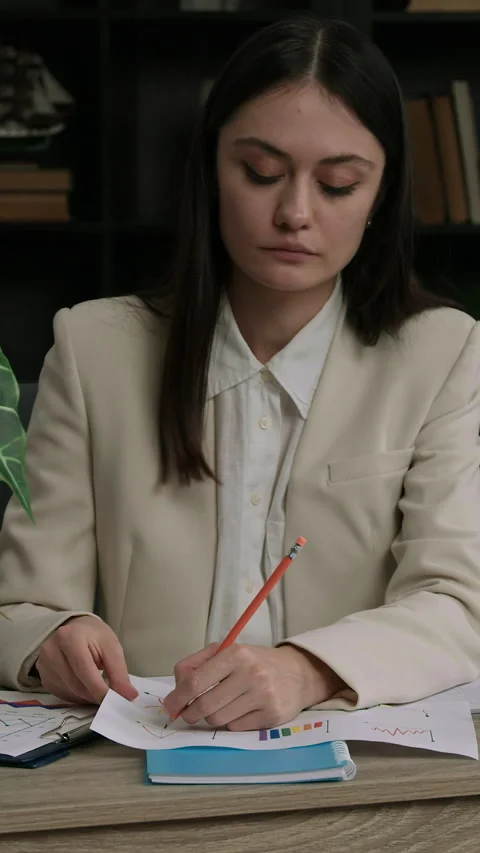 IT specialist analyzes several graphs and tables to work on an IT program. Stock Footage 305412381