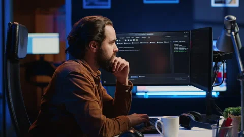 IT specialist sitting at computer desk, working on desktop PC Stock Footage 265510541