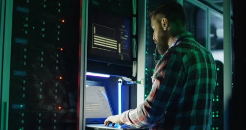 IT specialist speaking on phone while working in server room Stock Footage 97153044
