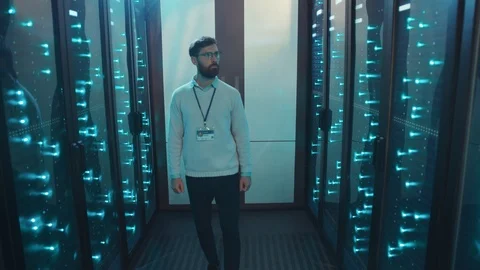 IT specialist walking in server rack corridor inspecting network system Stock Footage 119233720