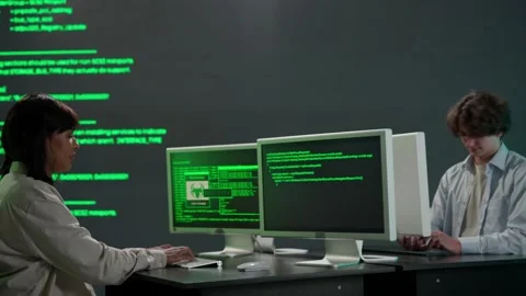 IT specialists against big digital screen. Man and woman programmers work on Stock Footage 265574876