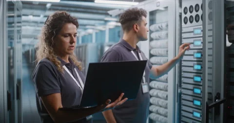 IT Specialists Collaborating on Laptop in Data Center Server Room Video stock 344888312