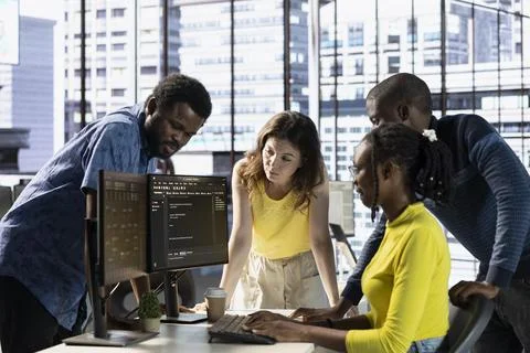 IT specialists working with colleagues, testing and deploying programs Foto stock
