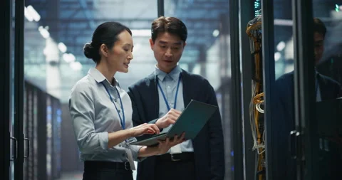 IT Specialists Working with Laptop Computer in Data Center Stock Footage 319998269