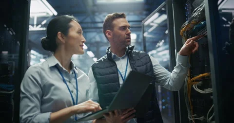 IT Specialists Working with Laptop Computer in Data Center Stock Footage 319999052