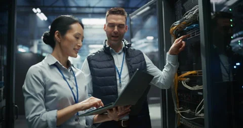 IT Specialists Working with Laptop Computer in Data Center Stock Footage 319999066