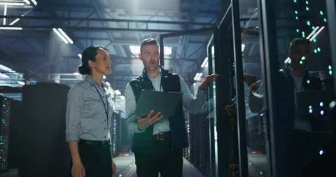 IT Specialists Working with Laptop Computer in Data Center Stock Footage 320001034