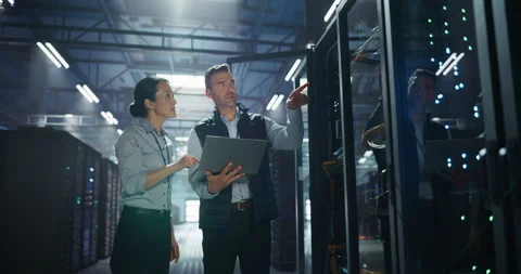 IT Specialists Working with Laptop Computer in Data Center Stock Footage 320001083