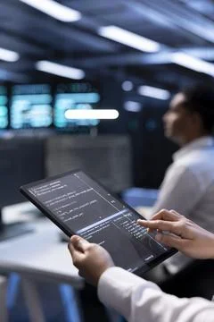 IT staff member using tablet in data center to check for systems bottlenecks 스톡 사진