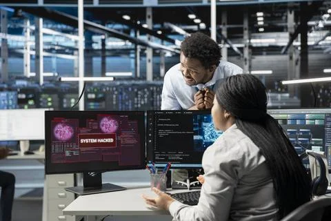 IT staff members in high tech facility trying to protect servers from hacker Stock Photos