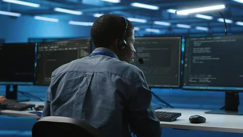 IT support expert in server room talking on headphones with admin 写真素材