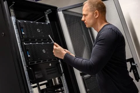 IT Support Holding Digital Tablet Analyzing Servers And Network In Datacenter Stock Photos