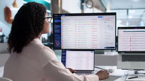 IT Support Specialist Carefully Manages Helpdesk Tickets Using Laptop Stock Footage 339911926