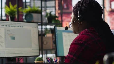 IT support specialist at PC in office helping customers during call Stock Footage 305390884
