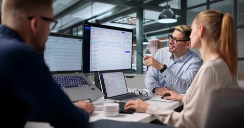 The IT Support Team Works Together Solving Customer Issues On Laptops. Stock Photos