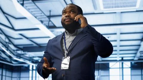 IT support worker in data center talking in phone call, doing yearly checkup Stock Photos