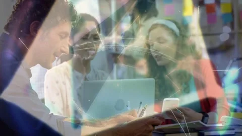 IT team tapping phones gesturing at laptop creating polygon overlay and rotating Stock Footage 331227646