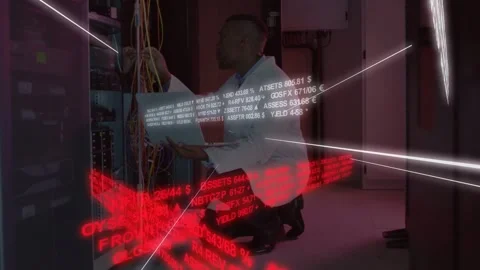 IT tech kneeling server rack checking laptop, routing cables while white ticker 動画素材 331713578