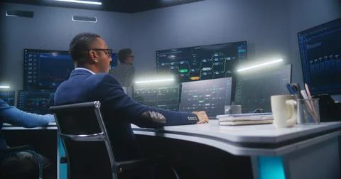 IT technical specialists sit in front of computers with data server Stock Photos