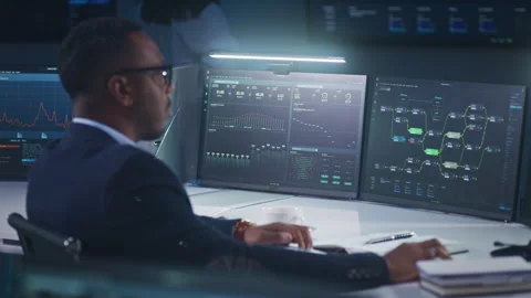 IT technical support specialist sits in front of computer with data server Stock Footage 244408841