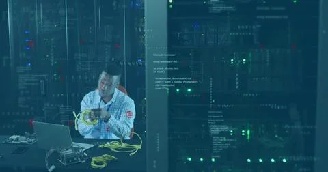 IT technician arranging Ethernet cables in server room racks with laptop, 写真素材