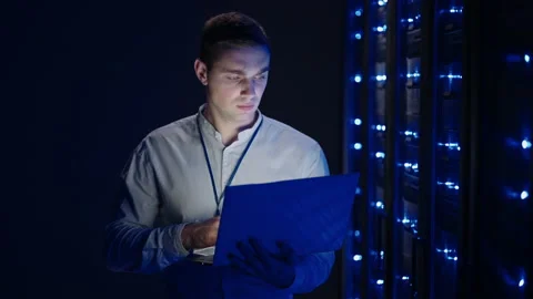 IT technician in data center digital server room controlling work of rack server Stock Footage 163142832