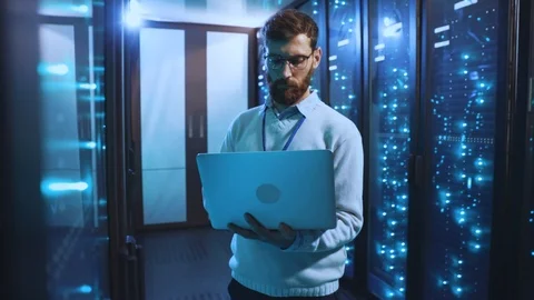 IT technician in glasses using notebook to check working system of computer Stock Footage 118450142