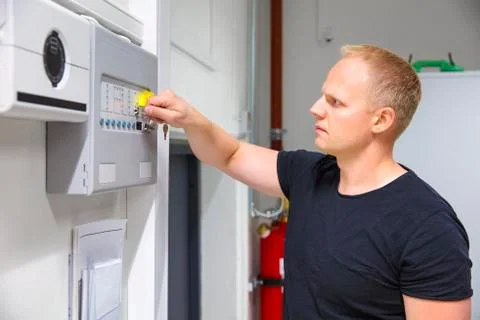 IT Technician Opening Fire Panel In Server Room Stock Photos