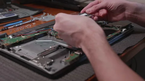 IT technician overhauls a RAM module of a notebook Stock Footage 137943537