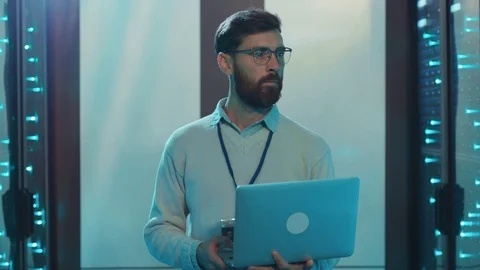 IT technician working in data center using laptop computer running diagnostics Stock Footage 119233673