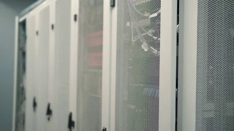 IT Technician Working On A Laptop Standing Before Open Server Rack Cabinet. 库存影片 103214093