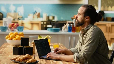 IT technician working remotely, coding on laptop, programming language Stock Photos