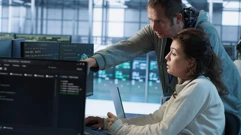 IT technicians in server farm brainstorming ways to repair equipment Stock Photos