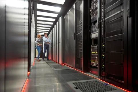 IT technicians talking at panel in server room Foto stock