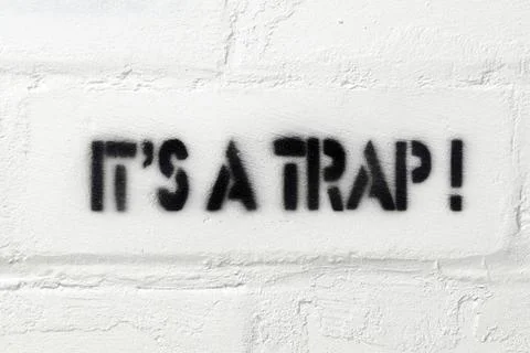It is a trap it s a trap exclamation stencil print on the white brick wall... Stock Photos
