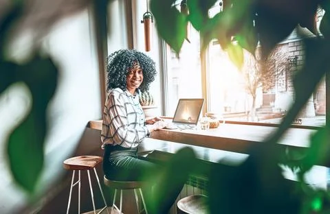 It is wonderful when the work is fun. A young african american is working or  Stock Photos