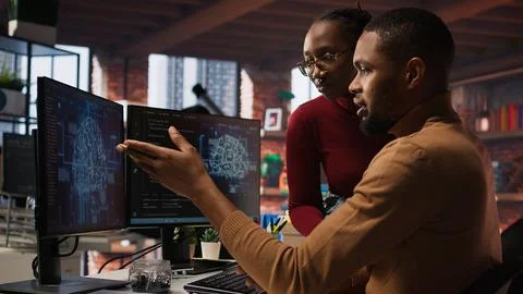IT worker and colleague programming in AI startup office to build applications Foto stock