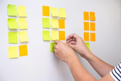 IT worker tracking his tasks on kanban board. Using task control of agile dev 写真素材