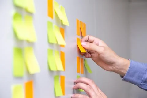 IT worker tracking his tasks on kanban board. Using task control of agile dev Stock Photos