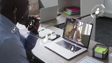 IT worker watching laptop as remote peer gesturing, sparking network nodes Stock Footage 333936831