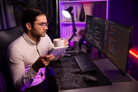 IT working with drinking coffee coding on pc screen, reading note. Surmise. Stock-Fotos