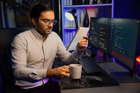 IT working with drinking coffee coding on pc screen, reading note. Surmise. Stock-Fotos