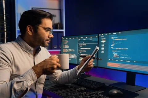 IT working with drinking coffee coding on pc screen, reading note. Surmise. Stockfoto's